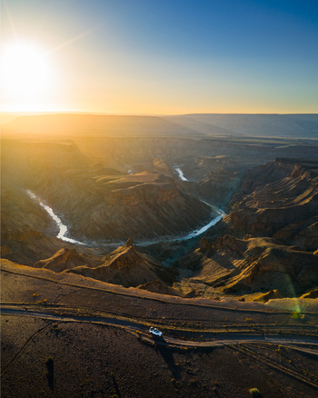 Aerial view of the Fish River Canyon s rugged landscape carved by the winding river under the golden sun Fish River Canyon Karas Region Namibia. Aerial view of the Fish River Canyon s rugged landscape carved by the winding river under the golden sun Fish River Canyon Karas Region Namibia.