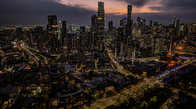 Aerial view of the Southbank skyline in Melbourne at twilight featuring illuminated skyscrapers busy city roads with light trails and the Arts Centre Melbourne spire Southbank Victoria Australia. Aerial view of the Southbank skyline in Melbourne at twilight featuring illuminated skyscrapers busy city roads with light trails and the Arts Centre Melbourne spire Southbank Victoria Australia.