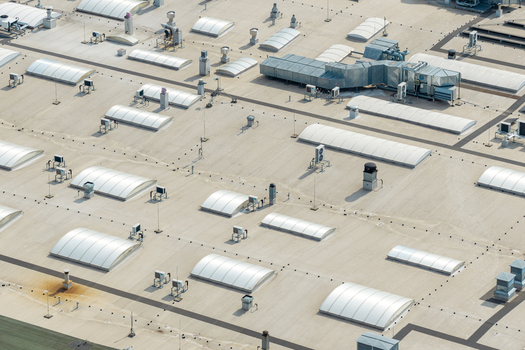 Aerial view of a large industrial warehouse roof featuring multiple arched skylights and HVAC ventilation systems in Warsaw Mazowieckie Poland. Aerial view of a large industrial warehouse roof featuring multiple arched skylights and HVAC ventilation systems in Warsaw Mazowieckie Poland.