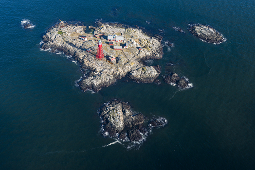 Aerial view of the iconic red Pater Noster lighthouse situated on a rocky island surrounded by deep blue sea in Kladesholmen Vastra Gotalands lan Sweden.