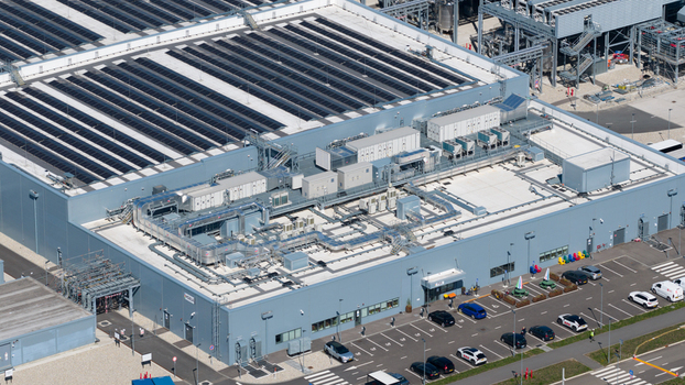 Aerial view of the HGB industrial facility with extensive rooftop solar panels HVAC units and a parking lot with cars Winschoten Groningen Netherlands.