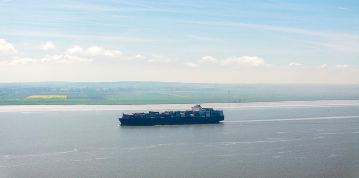 Brunsbuttel Schleswig Holstein Germany 30 May 2025 Aerial view of a large container ship sailing on the Elbe river near the green fields of the coast. Brunsbuttel Schleswig Holstein Germany 30 May 2025 Aerial view of a large container ship sailing on the Elbe river near the green fields of the coast.
