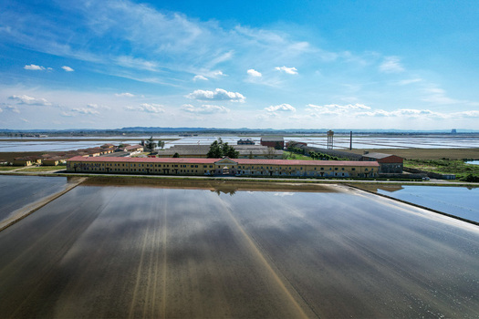 Aerial view of Azienda Agricola Veneria surrounded by flooded rice fields reflecting the blue sky in Veneria Piemonte Italy. Aerial view of Azienda Agricola Veneria surrounded by flooded rice fields reflecting the blue sky in Veneria Piemonte Italy.