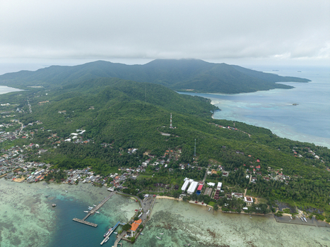 Aerial view of lush green island meeting the turquoise sea a vibrant contrast under the vast sky Karimunjawa Central Java Indonesia. Aerial view of lush green island meeting the turquoise sea a vibrant contrast under the vast sky Karimunjawa Central Java Indonesia.