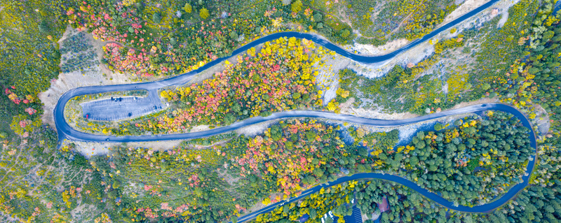 Aerial view of Alpine Loop Scenic Byway winding through vibrant autumn foliage with colorful trees and a small parking area in Utah County Utah United States. Aerial view of Alpine Loop Scenic Byway winding through vibrant autumn foliage with colorful trees and a small parking area in Utah County Utah United States.