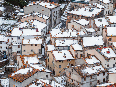 Aerial view of the historic village of Pescocostanzo with snow covered rooftops narrow stone streets and traditional architecture in Pescocostanzo Abruzzo Italy.