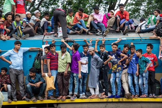 Dhaka Bangladesh 15 June 2018 View of Airport Railway Station with a crowd of people sitting on the roof and standing on the side of a moving train. Dhaka Bangladesh 15 June 2018 View of Airport Railway Station with a crowd of people sitting on the roof and standing on the side of a moving train.