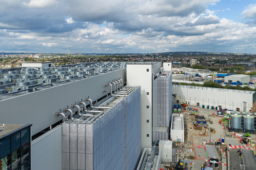Aerial view of a large data center facility with industrial cooling units on the roof and construction equipment on the site United Kingdom. Aerial view of a large data center facility with industrial cooling units on the roof and construction equipment on the site United Kingdom.