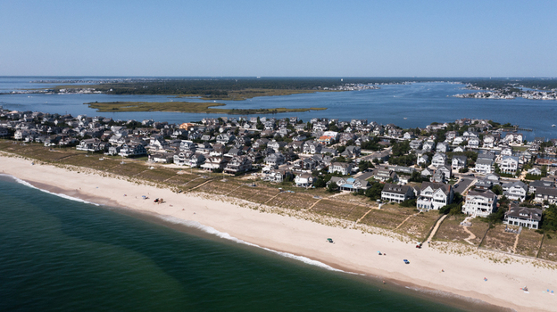 Aerial view of Mantoloking featuring residential houses along the sandy beach with the Atlantic Ocean and Barnegat Bay in the background Mantoloking New Jersey United States.