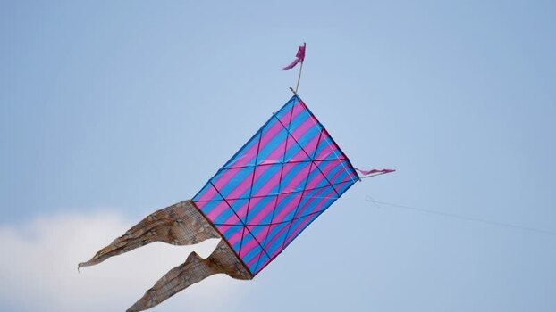 View of a large striped kite flying in the blue sky Bangladesh. View of a large striped kite flying in the blue sky Bangladesh.