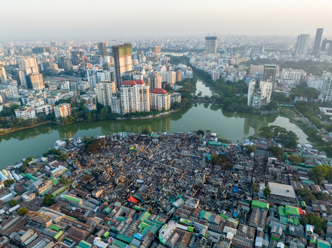 Aerial view of contrasting landscapes where modern buildings meet informal settlements along the serene lake Dhaka Dhaka Division Bangladesh. Aerial view of contrasting landscapes where modern buildings meet informal settlements along the serene lake Dhaka Dhaka Division Bangladesh.