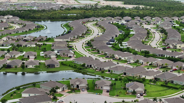 Aerial view of a suburban residential neighborhood with winding streets single family homes and man made canals in Cape Coral Florida United States.