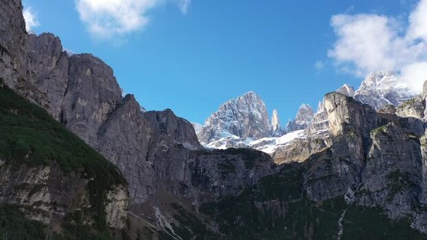 Aerial view of the Dolomites of Brenta group mountains with snow capped peaks and rugged limestone cliffs under a blue sky in Molveno Trentino South Tyrol Italy. Aerial view of the Dolomites of Brenta group mountains with snow capped peaks and rugged limestone cliffs under a blue sky in Molveno Trentino South Tyrol Italy.