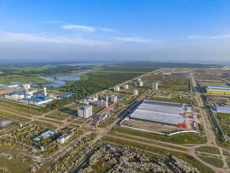 Aerial view of Mirsarai Economic Zone featuring industrial warehouses factory buildings and surrounding green landscape under a clear blue sky in Minsarai Chittagong Division Bangladesh. Aerial view of Mirsarai Economic Zone featuring industrial warehouses factory buildings and surrounding green landscape under a clear blue sky in Minsarai Chittagong Division Bangladesh.