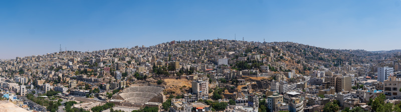 View of the historic Roman Theatre nestled among the dense urban landscape and hills of Amman Amman Governorate Jordan.