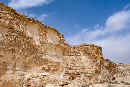 View of sun kissed cliffs rise with layered textures beneath a vast blue sky dotted with soft clouds in Wadi Degla Protectorate Cairo Cairo Governorate Egypt. View of sun kissed cliffs rise with layered textures beneath a vast blue sky dotted with soft clouds in Wadi Degla Protectorate Cairo Cairo Governorate Egypt.