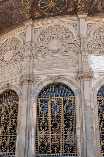 View of the Sabil Kuttab of Muhammad Ali Pasha featuring intricate stone carvings and ornate arched windows with decorative metal grilles in Cairo Egypt. View of the Sabil Kuttab of Muhammad Ali Pasha featuring intricate stone carvings and ornate arched windows with decorative metal grilles in Cairo Egypt.