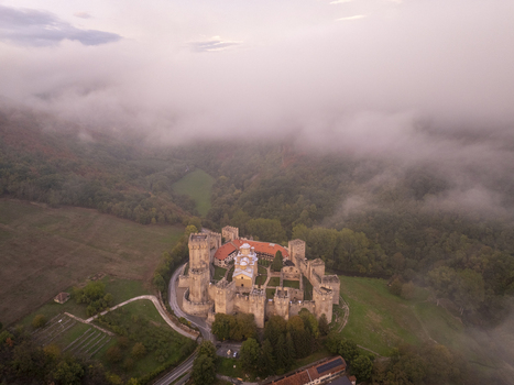 Aerial view of Manasija Monastery surrounded by thick morning fog historic stone walls and towers nestled in the lush green landscape of Despotovac Pomoravski okrug Serbia.