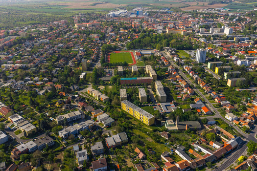 Aerial view of the town of Kyjov featuring residential buildings a sports field with a running track green spaces and surrounding landscape in Kyjov South Moravian Region Czechia.