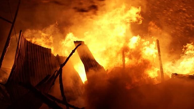View of intense fire engulfing structures at night Bangladesh. View of intense fire engulfing structures at night Bangladesh.