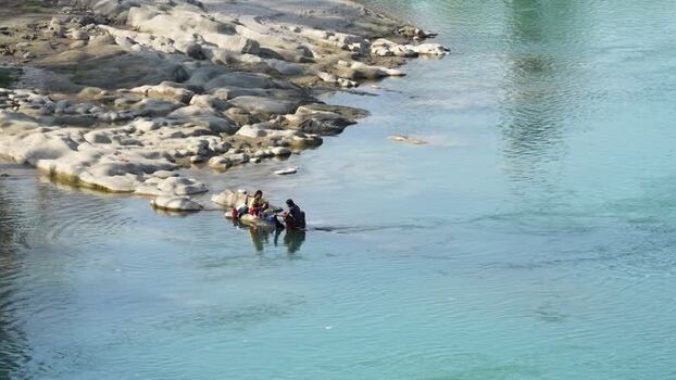View of people washing clothes by the river in Surkhet Nepal.