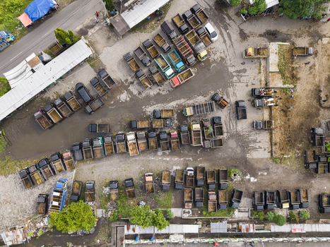 Aerial view of the Animal Market Prambanan with rows of trucks parked on a dirt ground during a busy trading day Kecamatan Prambanan Jawa Tengah Indonesia. Aerial view of the Animal Market Prambanan with rows of trucks parked on a dirt ground during a busy trading day Kecamatan Prambanan Jawa Tengah Indonesia.