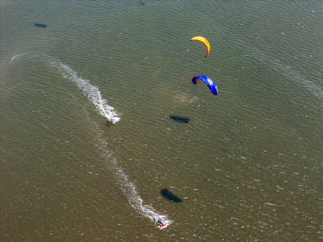 Aerial view of kite surfers gliding over the water at Depok Beach Special Region of Yogyakarta Indonesia.