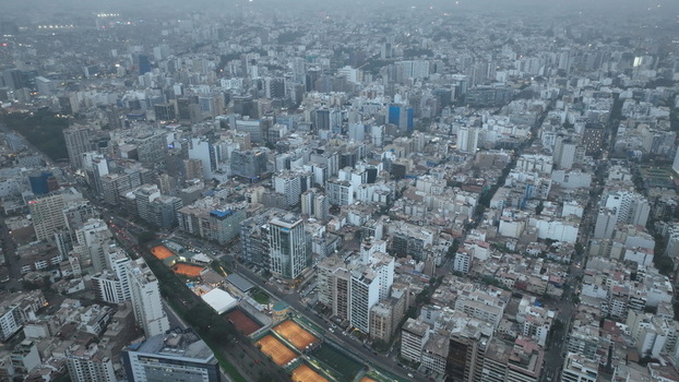 Aerial view of the dense urban landscape of Miraflores featuring high rise buildings residential streets and tennis courts in Miraflores Provincia de Lima Peru. Aerial view of the dense urban landscape of Miraflores featuring high rise buildings residential streets and tennis courts in Miraflores Provincia de Lima Peru.