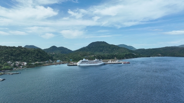 Aerial view of a cruise ship docked at the port in Sabang surrounded by lush green hills and calm blue waters in Sabang Aceh Indonesia. Aerial view of a cruise ship docked at the port in Sabang surrounded by lush green hills and calm blue waters in Sabang Aceh Indonesia.