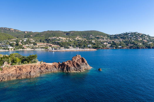 Aerial view of Le Trayas with red rock formations jutting into the Mediterranean sea surrounded by coastal hills and the town of Saint Raphael Provence Alpes Cote d Azur France. Aerial view of Le Trayas with red rock formations jutting into the Mediterranean sea surrounded by coastal hills and the town of Saint Raphael Provence Alpes Cote d Azur France.