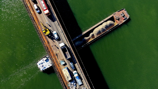 Aerial view of the Smederevo bridge over the Danube river with traffic and a barge carrying cargo in Smederevo Podunavlje District Serbia.