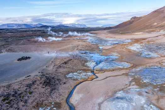 Aerial view of Hverir geothermal field with steaming fumaroles bubbling mud pools and mineral rich soil in the volcanic landscape of Reykjahlid Thingeyjarsveit Iceland.