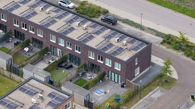 Aerial view of modern terraced houses in the Nobelhorst neighborhood featuring solar panels on flat roofs and private backyards in Almere Flevoland Netherlands. Aerial view of modern terraced houses in the Nobelhorst neighborhood featuring solar panels on flat roofs and private backyards in Almere Flevoland Netherlands.