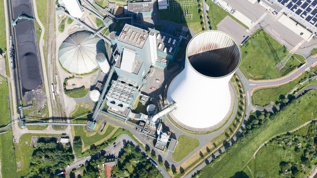 Aerial view of the Walsum power plant with its large cooling tower industrial facilities and coal storage area surrounded by green fields and roads in Duisburg Nordrhein Westfalen Germany. Aerial view of the Walsum power plant with its large cooling tower industrial facilities and coal storage area surrounded by green fields and roads in Duisburg Nordrhein Westfalen Germany.