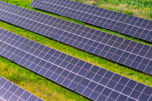 Aerial view of rows of solar panels installed in a grassy field in Gdansk Pomeranian Voivodeship Poland.