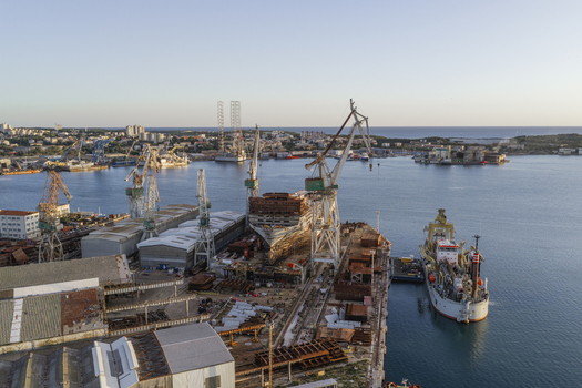 Aerial view of the Uljanik Shipyard with large industrial cranes a ship under construction in the dry dock and harbor facilities along the Adriatic Sea Pula Istarska zupanija Croatia. Aerial view of the Uljanik Shipyard with large industrial cranes a ship under construction in the dry dock and harbor facilities along the Adriatic Sea Pula Istarska zupanija Croatia.