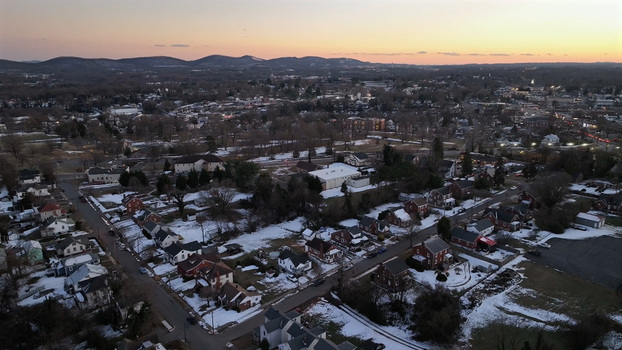 Aerial view of residential neighborhood in Southwest Lynchburg at sunset with snow covered rooftops bare trees and distant mountains in Lynchburg Virginia United States. Aerial view of residential neighborhood in Southwest Lynchburg at sunset with snow covered rooftops bare trees and distant mountains in Lynchburg Virginia United States.