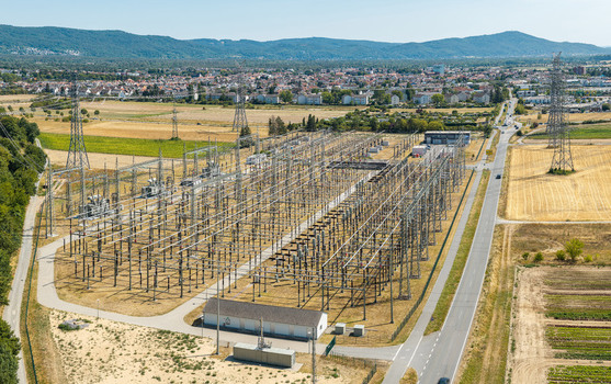 Aerial view of the Amprion Umspannwerk electrical substation surrounded by agricultural fields and power lines near the town of Pfungstadt Hessen Germany.