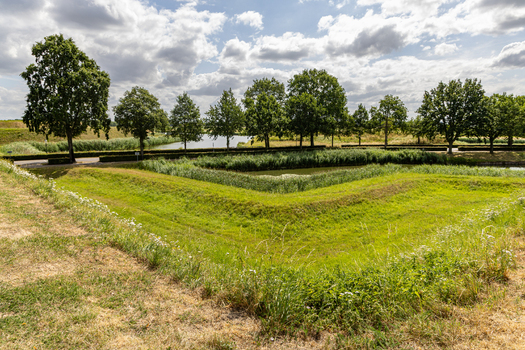 View of the historic grassy ramparts and moat surrounding the fortified town of Heusden North Brabant Netherlands.