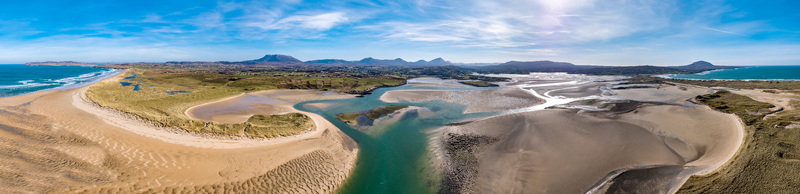 Aerial view of Ballyness Bay featuring expansive sandy tidal flats winding channels of water and surrounding coastal dunes in Ballyness County Donegal Ireland. Aerial view of Ballyness Bay featuring expansive sandy tidal flats winding channels of water and surrounding coastal dunes in Ballyness County Donegal Ireland.
