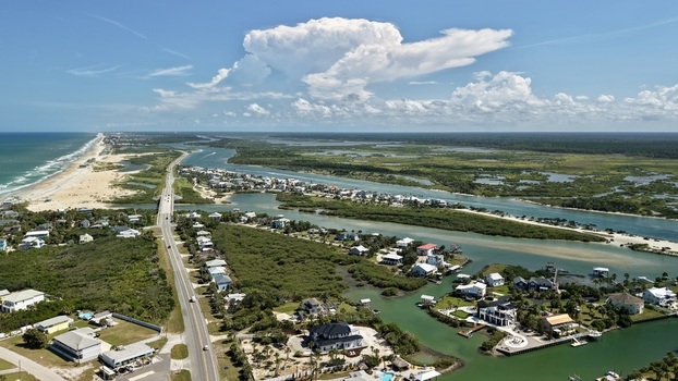 Aerial view of Matanzas Inlet with its coastal bridge surrounding marshlands residential houses and the Atlantic Ocean coastline in St. Johns County Florida United States. Aerial view of Matanzas Inlet with its coastal bridge surrounding marshlands residential houses and the Atlantic Ocean coastline in St. Johns County Florida United States.