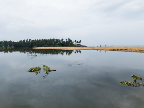 Aerial view of a tropical lagoon and sandy beach with palm trees under an overcast sky in Galle Southern Province Sri Lanka. Aerial view of a tropical lagoon and sandy beach with palm trees under an overcast sky in Galle Southern Province Sri Lanka.