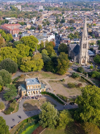 Aerial view of Clissold Park and St Mary s Church with lush trees pathways and people gathered near the historic house in Stoke Newington London England United Kingdom. Aerial view of Clissold Park and St Mary s Church with lush trees pathways and people gathered near the historic house in Stoke Newington London England United Kingdom.