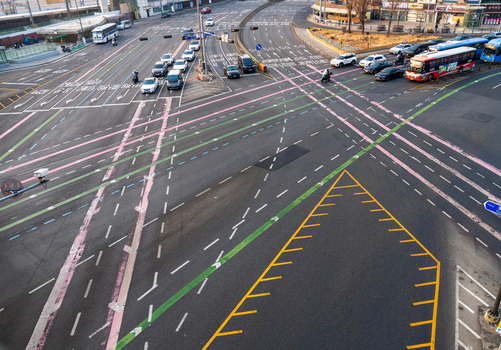 Busan South Korea 21 February 2026 Aerial view of a busy intersection with cars and buses navigating marked lanes and crosswalks in the city. Busan South Korea 21 February 2026 Aerial view of a busy intersection with cars and buses navigating marked lanes and crosswalks in the city.