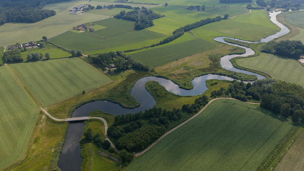 Aerial view of the winding Berkel river flowing through lush green meadows and agricultural fields in the rural landscape of Almen Gelderland Netherlands. Aerial view of the winding Berkel river flowing through lush green meadows and agricultural fields in the rural landscape of Almen Gelderland Netherlands.