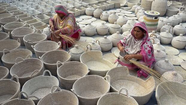 View of women weaving traditional baskets in Bogura Bangladesh. View of women weaving traditional baskets in Bogura Bangladesh.