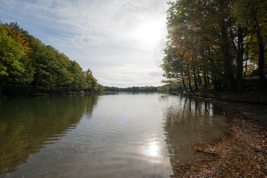 View of Pocuvadlo Lake with autumn trees and calm water reflecting the bright sky in Banska Stiavnica Banskobystricky kraj Slovakia. View of Pocuvadlo Lake with autumn trees and calm water reflecting the bright sky in Banska Stiavnica Banskobystricky kraj Slovakia.