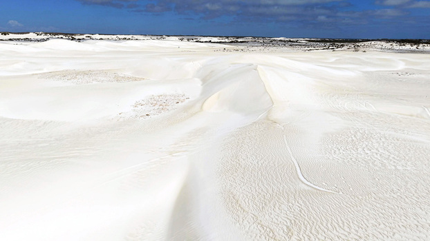Aerial view of the Lancelin Sand Dunes featuring vast white sand formations under a clear blue sky in Lancelin Western Australia Australia. Aerial view of the Lancelin Sand Dunes featuring vast white sand formations under a clear blue sky in Lancelin Western Australia Australia.