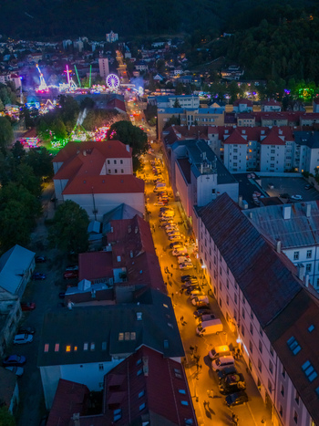 Aerial view of the Radvansky jarmok traditional market at night with illuminated fairground rides a glowing Ferris wheel and historic buildings in Banska Bystrica Banskobystricky kraj Slovakia.