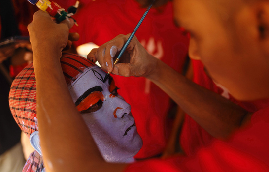 Munshiganj Bangladesh 13 April 2025 View of intricate face painting with vivid purple and orange strokes transforming a subject s face amidst contrasting red textures. Munshiganj Bangladesh 13 April 2025 View of intricate face painting with vivid purple and orange strokes transforming a subject s face amidst contrasting red textures.